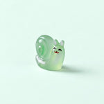 Miniature Glow Snail Assorted (1pc) displayed on a mint green background