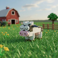 Cow building block in a grassy field with a red barn in the background