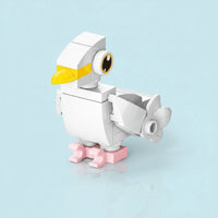Toy figure of a Dove Building Block with a yellow beak on a light blue background