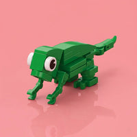 Green toy lizard made of interlocking bricks on a pink background