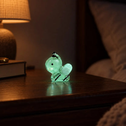 Miniature Glow Bee Assorted (1pc) glowing on a wooden table in a dimly lit room