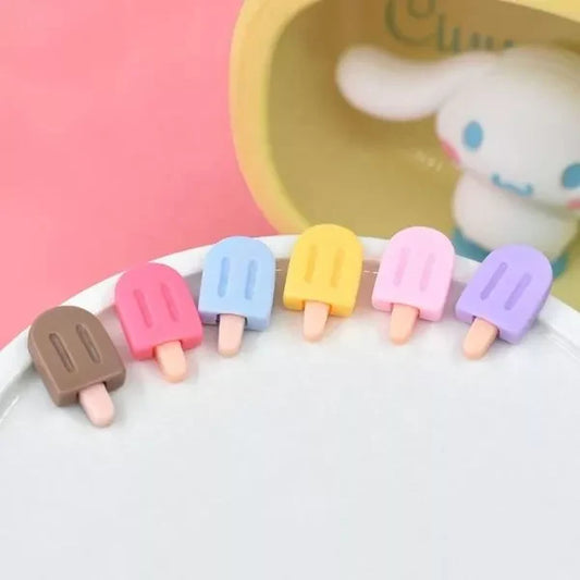A set of colorful Miniature Dollhouse Ice Cream kept on a plate with a doll in the background.
