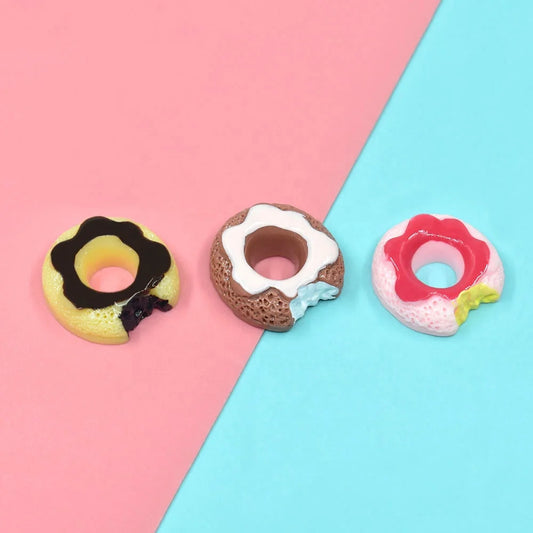 3 different colorful Miniature Dollhouse Doughnuts on a blue and pink floor.