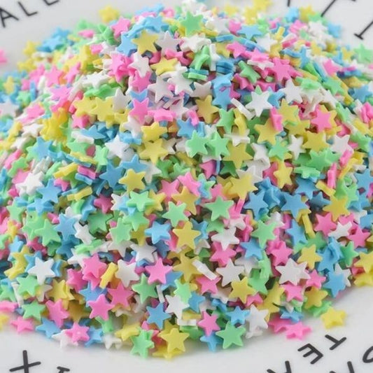 Several colorful Miniature Polymer Clay Stars pile on a floor.