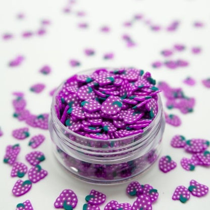 A beautiful Miniature Polymer Clay Grapes in a small glass container with similar several Miniature Polymer Clay Grapes on the floor.
