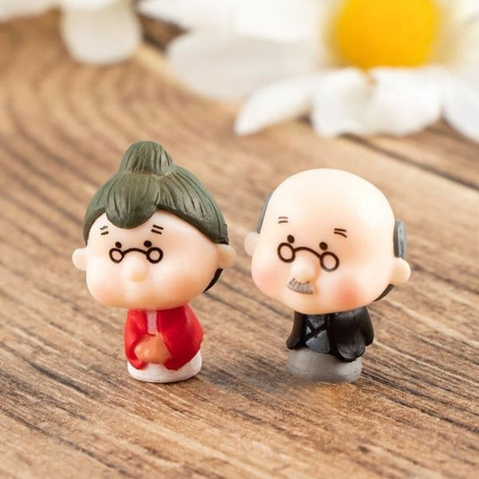 A cute Miniature Old Couple Grandparents kept on a wooden table.