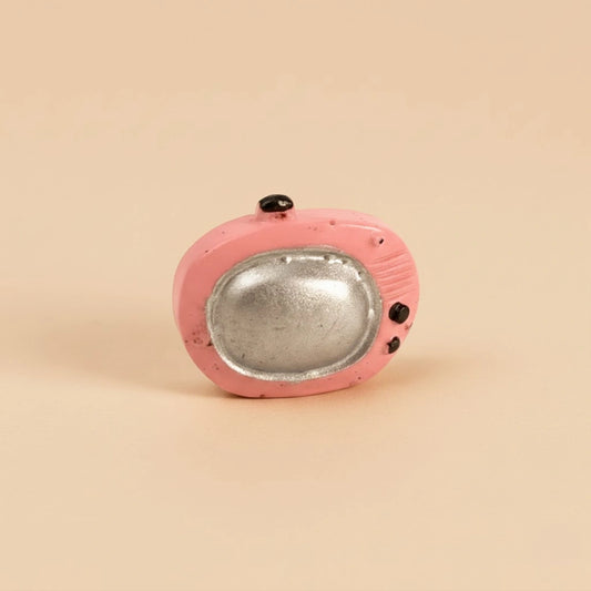 Miniature Toy TV figure on the light pink background.